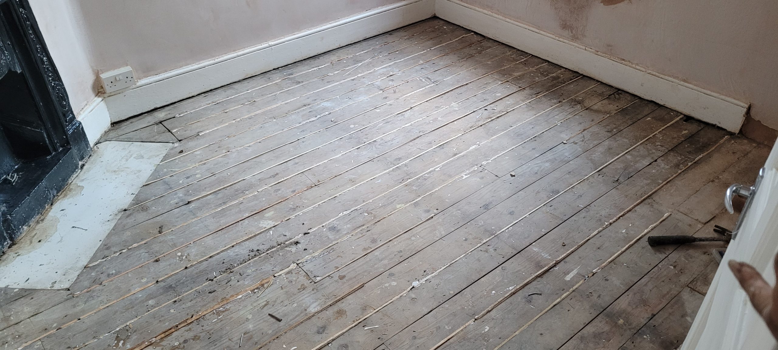 Room with worn Victorian pine floorboards awaiting restoration through Transforming Victorian Boards.