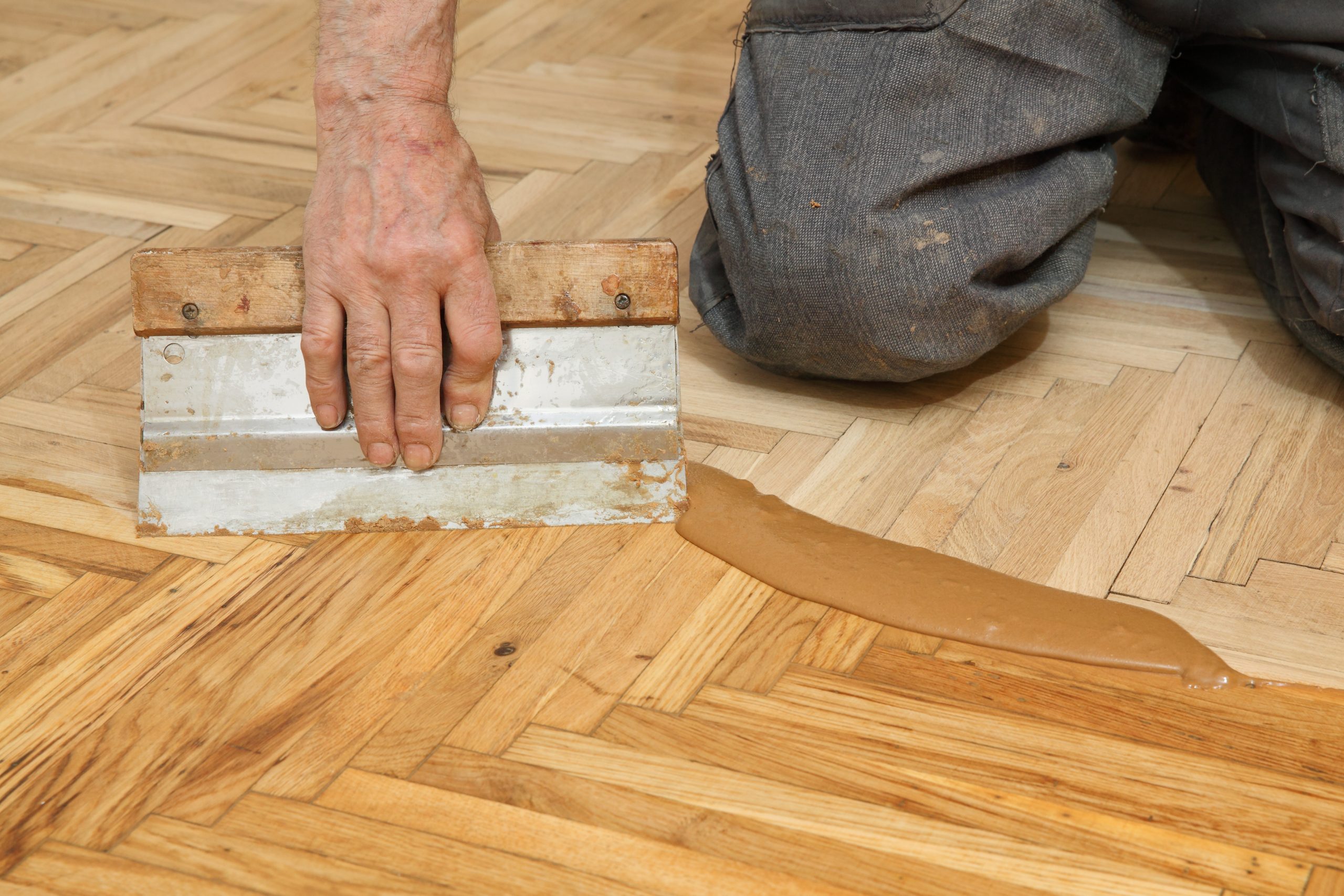 Heritage Parquet in Isleworth – Oak Herringbone Parquet Gap Filling Heritage Parquet gap filling in Isleworth — oak herringbone parquet wood floor being trowel-filled with resin/dust slurry before final sanding and sealing.