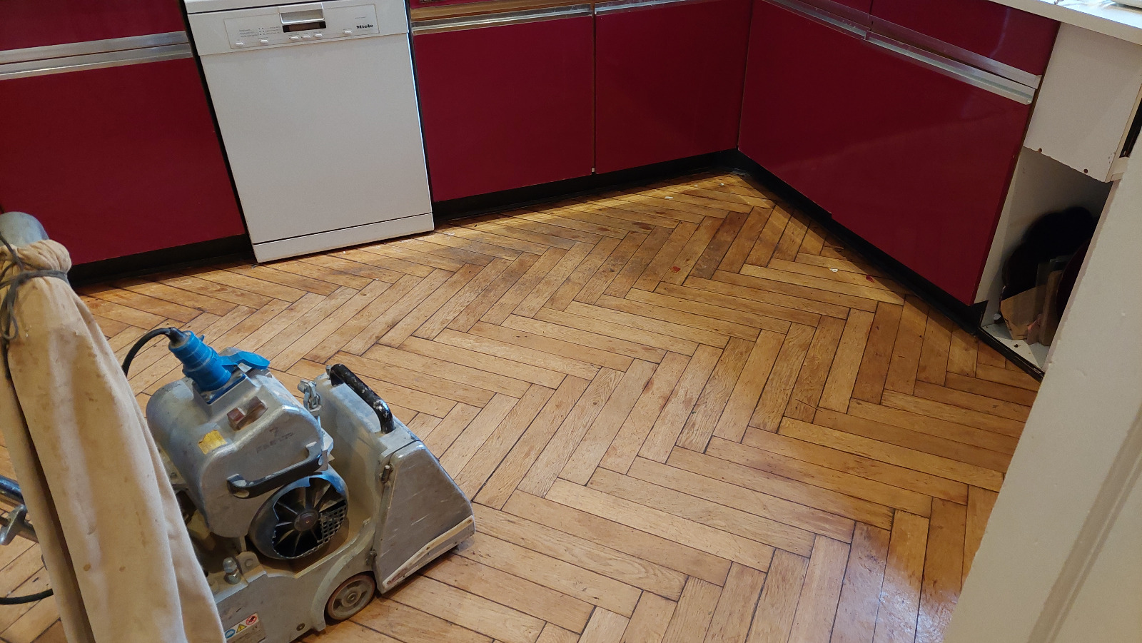 Parquet Floor Sanding in Isleworth on an oak herringbone kitchen floor using a professional drum sander.
