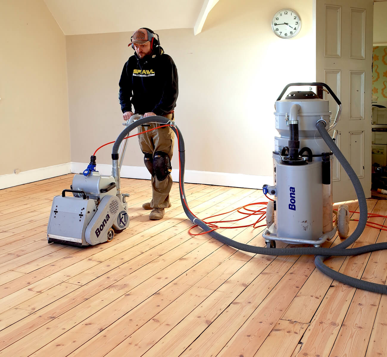 Wood Floor Sanding in an Isleworth bedroom, with a specialist using dust-free Bona equipment on original softwood pine floorboards for a smooth, even finish.