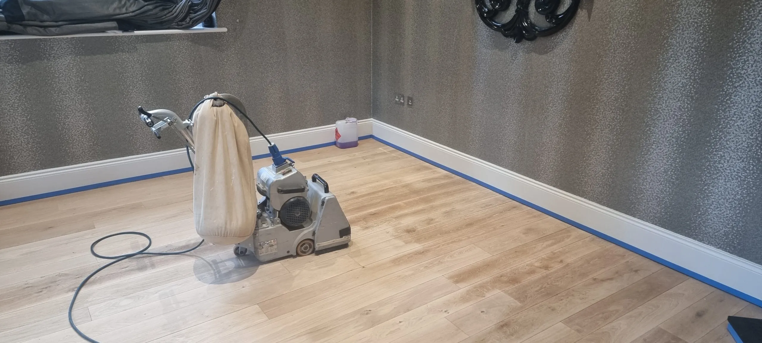 Wood Floor Sanding in Isleworth bedroom with light oak hardwood plank flooring prepared and sanded smooth, ready for sealing and refinishing.